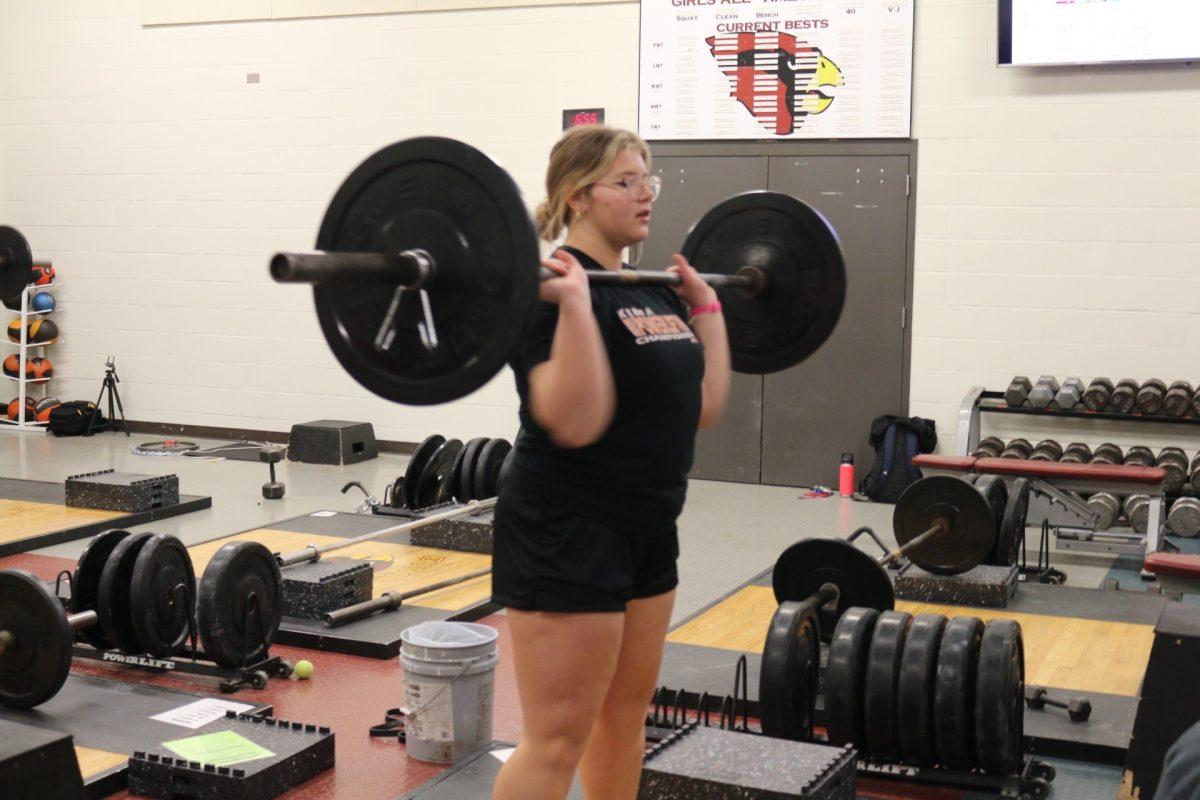 Junior Brennan Moeckel performs a warm-up rep on hang clean to get loose during practice Thursday.