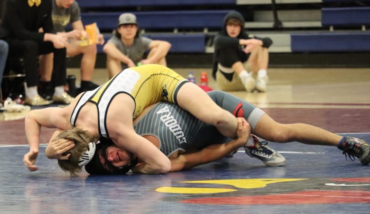 Junior Alex Clobes moves his feet to try and get back up from underneath his opponent. Clobes ended up losing his matchup in the meet against Paola.