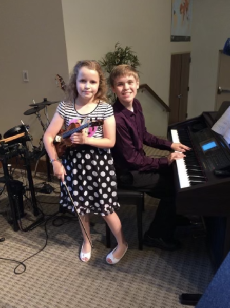 Submitted photo. Shoemaker poses with her brother at her first violin recital. When she learned her brother was starting guitar lessons, she decided she wanted to play something more complicated.