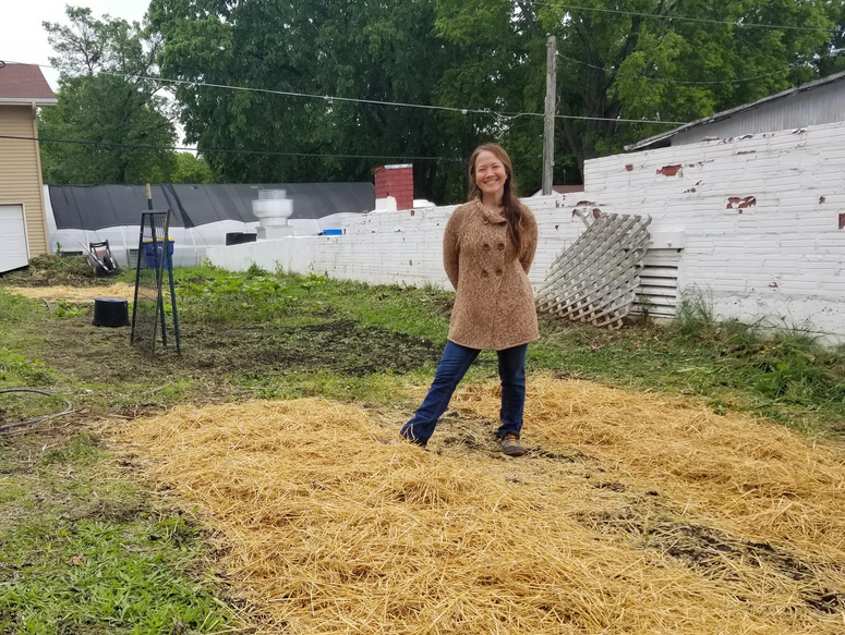 Mary Kirkendoll stands in the community garden and shows the progress that has been made.