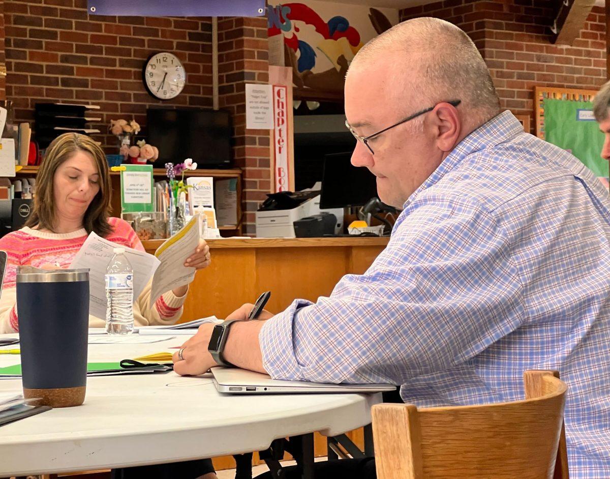 Library Board Vice President Eric Magette and treasurer Amy Jankowski look through drafts of the community survey at Tuesday&#8217;s meeting.