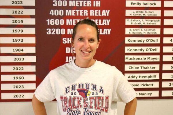 New head track and field coach MaryJo Swann is ready to build off last season’s success as she stands in front of the school record board. Swann inherits a girls team that placed third at state and a boys team that placed sixth. 
