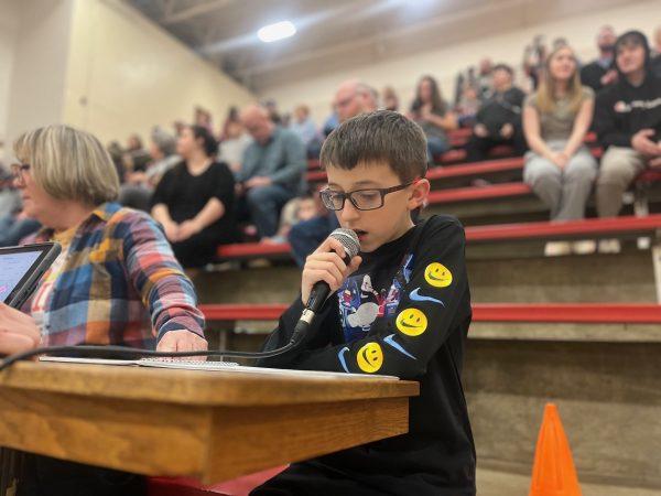 Seventh grader Kamden Gentry reads the starting lineups for a middle school basketball game on Tuesday. Gentry has announced games for the last year, trying to bring energy and joy to fans and players.