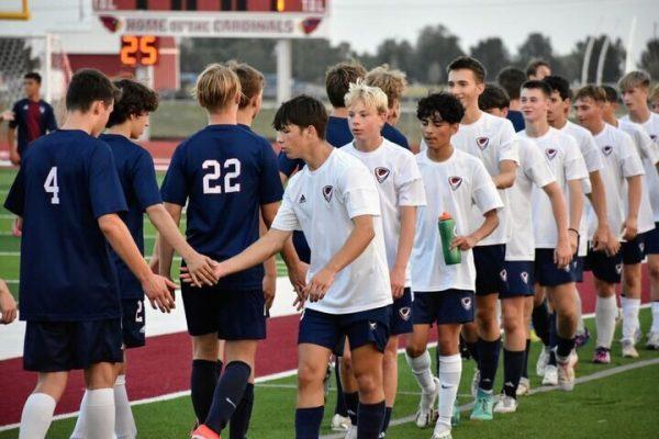 Boys soccer players high five after a close scrimmage ended in a 1-1 draw. The team showcased its depth with two full team rotating players in the tight battle.