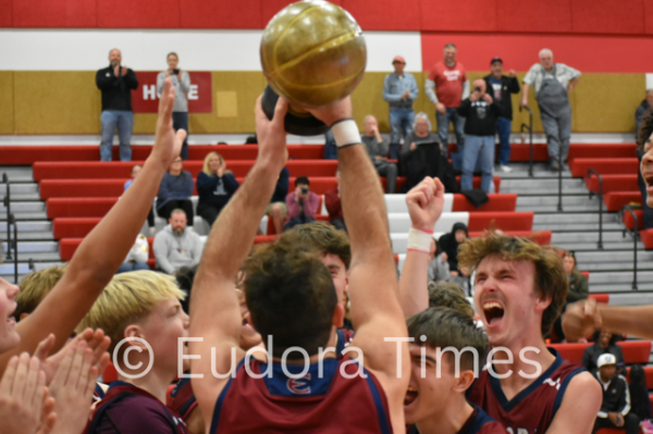 Cardinals boys basketball players hoist the trophy after winning the Tonganoxie tournament Saturday night.
 