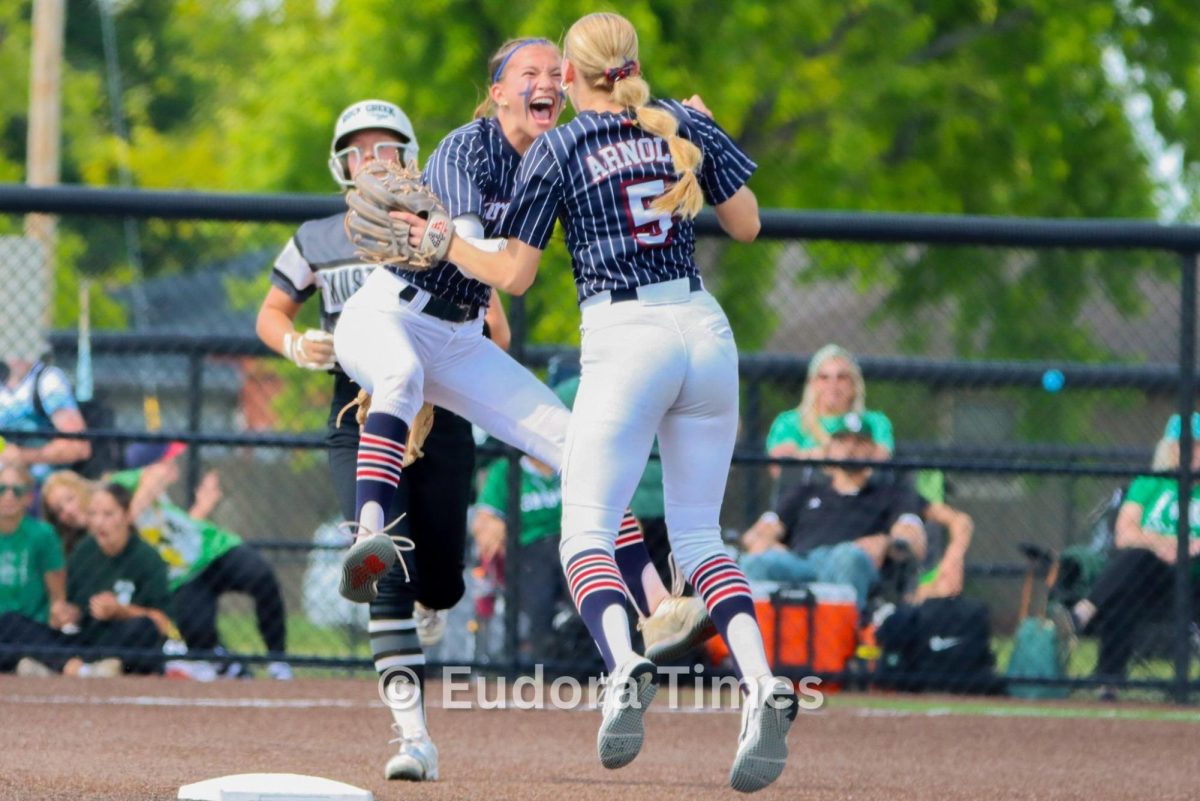 Seniors Katie Courter and Maddy Arnold celebrate after Courter made a diving catch and double play to get the Cardinals out of a jam Thursday. The Cardinals defeated Rock Creek 4-0 in the state quarterfinals.  