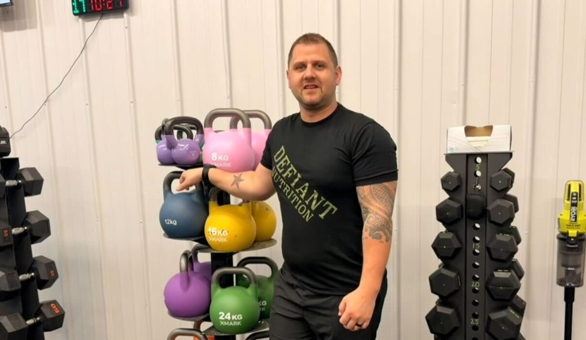 Ty Hendon stands in front of workout equipment on Friday at the Defiant Fitness studio.