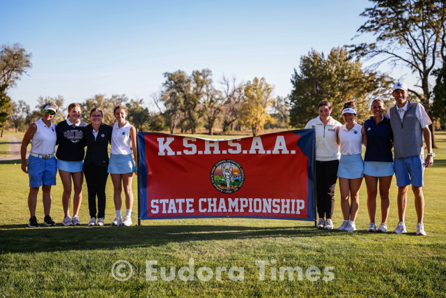 The Cardinals girls golf team poses with the KSHSAA state championship banner at the state golf tournament. Senior Marleigh Grant and junior Brooklynn Akers qualified for the second day. 