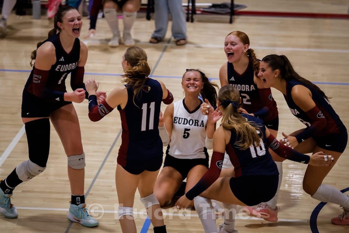 The Cardinals volleyball team celebrates after clinching its first league title since 2007. They defeated Paola in four sets Tuesday night. 