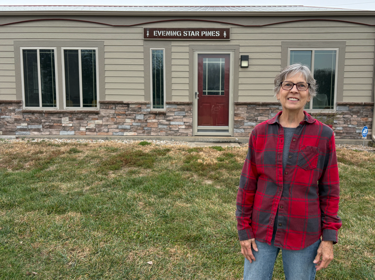 Sherry Crawford in front of the Evening Star Pines gift shop, where they sell mittens, wreaths, gnomes and jams.