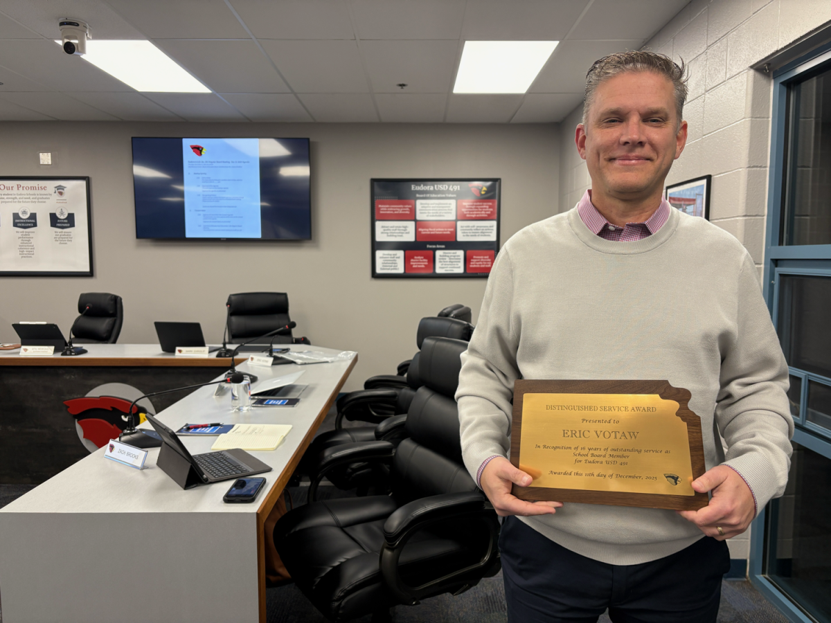 Eric Votaw receives a plaque at his last School Board meeting Thursday.