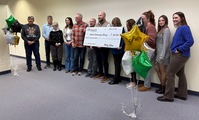 Library Board members and library and bank staff pose for a photo with the $25,000 check, which Board President Kenny Massey said will be used for projects like firewall renovations and ADA bathrooms.